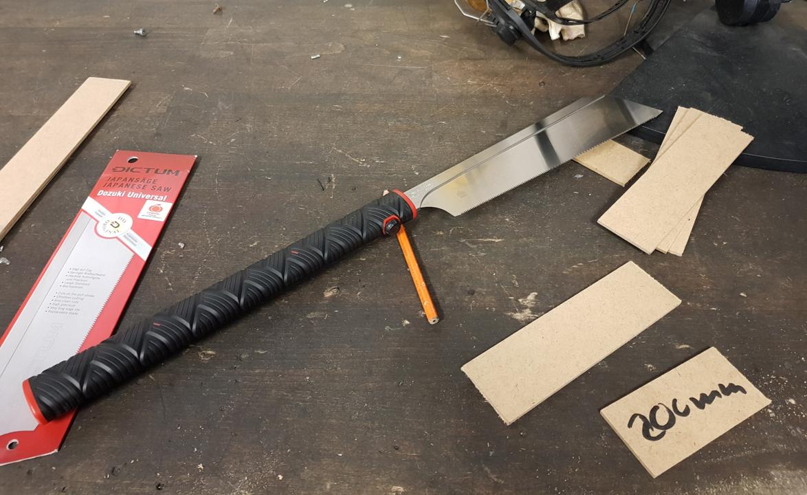 Saege mit Holzstuecken auf der Werkbank.