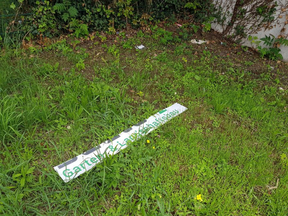 Ein Teil eines Plakats liegt auf dem Gras.