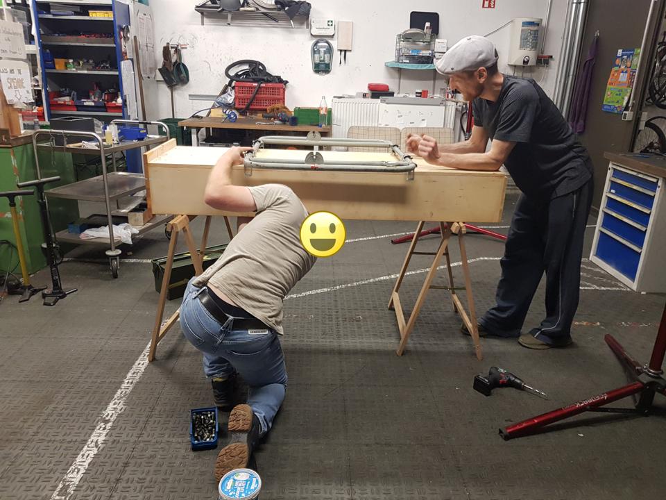 Ben und Alex schrauben das Fahrgestell an den Kasten.
